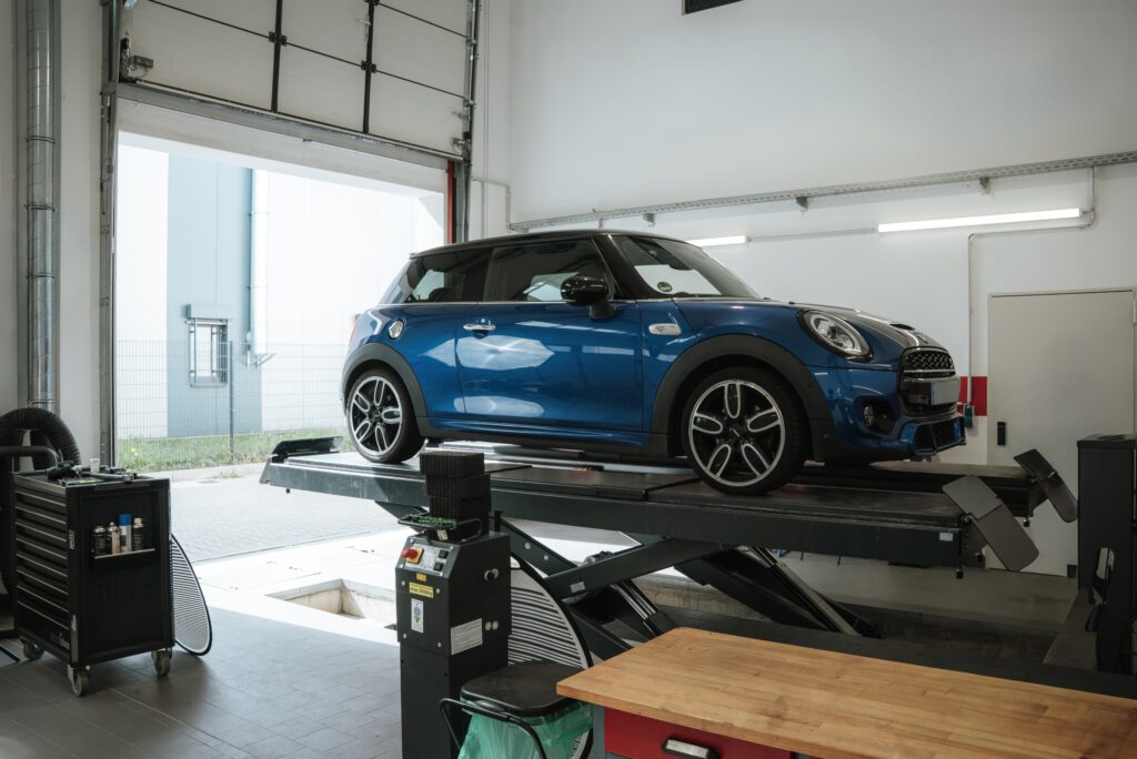 Blauer Mini auf der Hebebühne in der Prüfhalle
